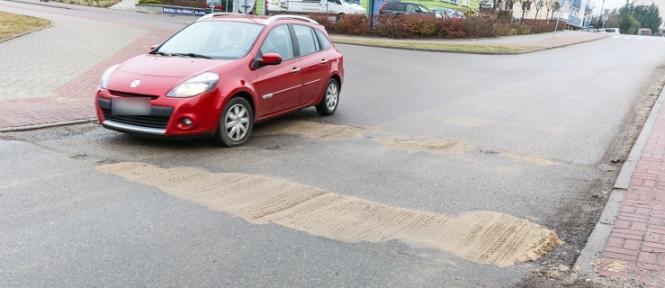 Wyrwy w asfalcie przy wjeździe do „Ogrodów”. Kiedy naprawa?