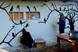 Aleksandra Sowińska i Aleksandra Biedrzycka wykonują ptasi mural w centrum Elbląga